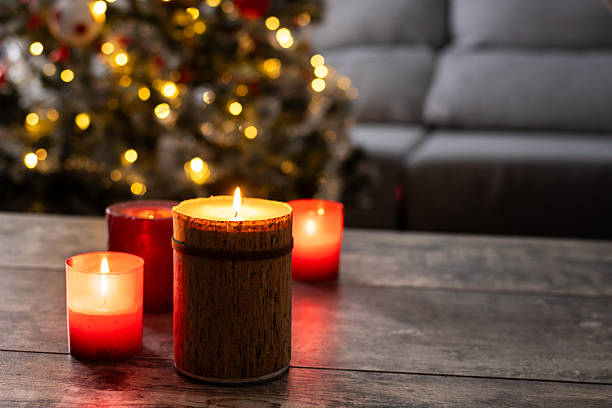istock Red Christmas candles with holiday lights and tree in background 2239734827