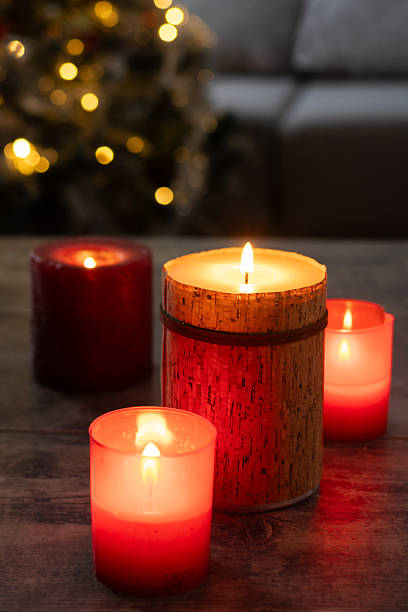 istock Red Christmas candles with holiday lights and tree in background 2239734854