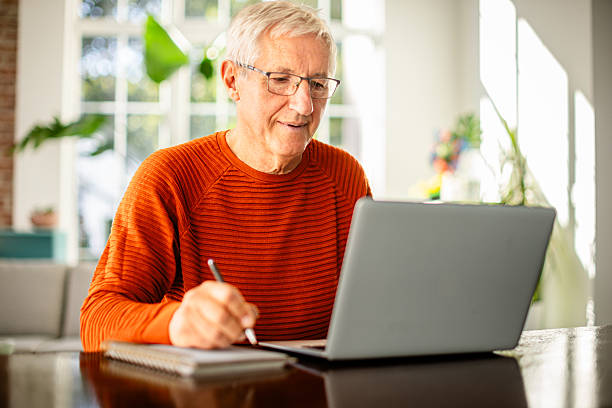 istock Senior man enjoys working from home in his well-lit office, finding joy in his tasks and embracing retirement 2239735910
