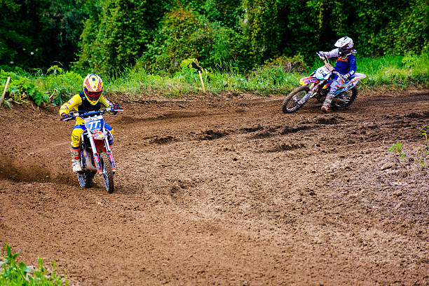 Sports photo of biker who is a professional rider in enduro and motocross outside. Off-road bike and man in the nature making stunt. Forest and sand, the person using sport eqipment.