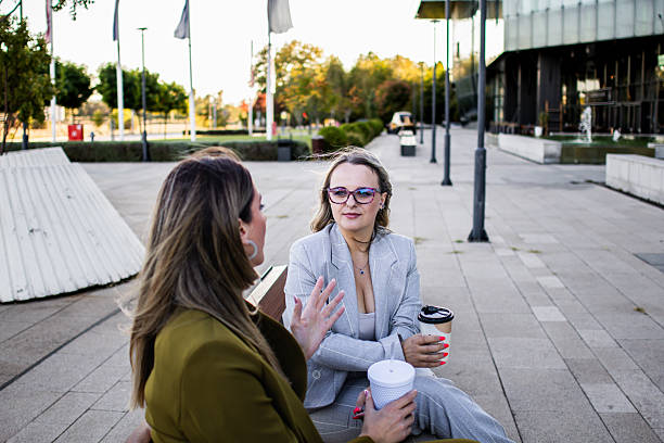 istock Two female business colleagues chatting during coffee break and enjoying friendly conversation outside corporate office building, 2239739665