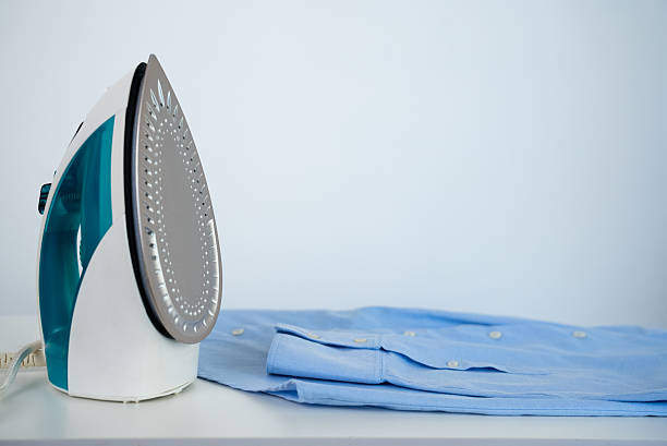 istock Steam iron standing on blue shirt 2239741817