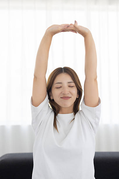 istock Woman stretching on sofa in bright living room 2239744967