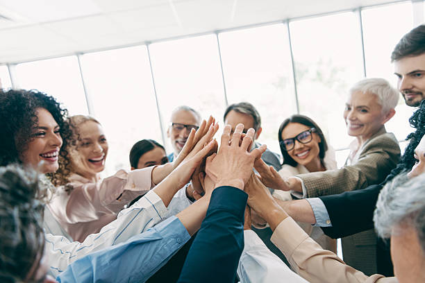 istock Diverse coworkers celebrating teamwork with a cheerful and collaborative gesture at an office environment during a group meeting 2239748038