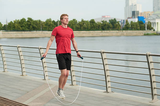 istock Young Man Exercising Outdoors Jumping Rope near River 2239748147