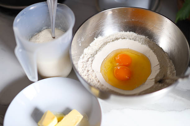 Baking ingredients: eggs, flour, butter, and sugar in preparation for mixing.