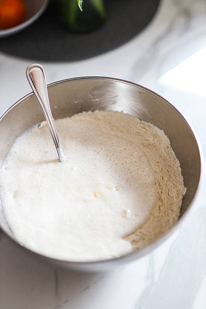 istock Mixing bowl with flour and milk on marble countertop 2239748949