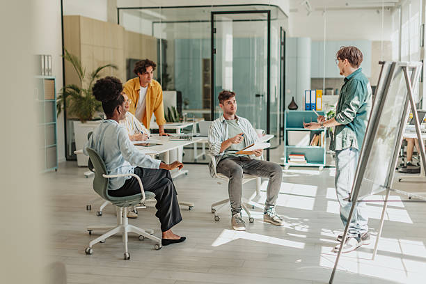 istock Group of young professionals collaborating in a modern office space during a brainstorming session with a positive atmosphere 2239749184