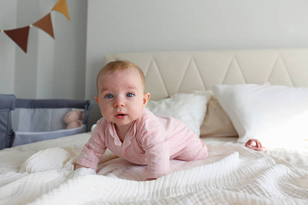 istock Six months old baby on the bed. 2239749369