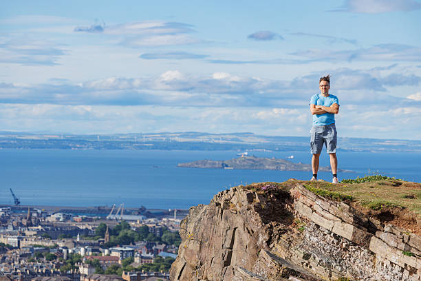 istock Confident hiker stand on a steep cliff in Edinburgh, Scotland 2239751496