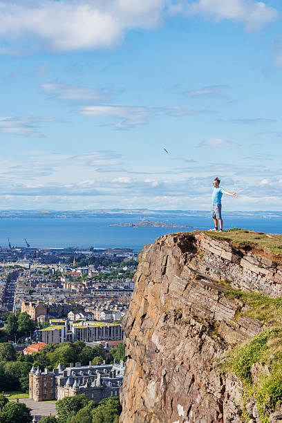 istock Man on a cliff enjoys Scottish highlands breathtaking panorama 2239751504