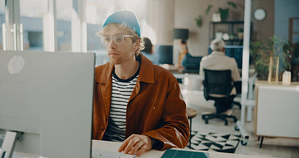 istock Reading, computer or business man in agency for software development, online project or review. Desktop, serious or frontend developer with internet update, creative problem solving or website design 2239752551