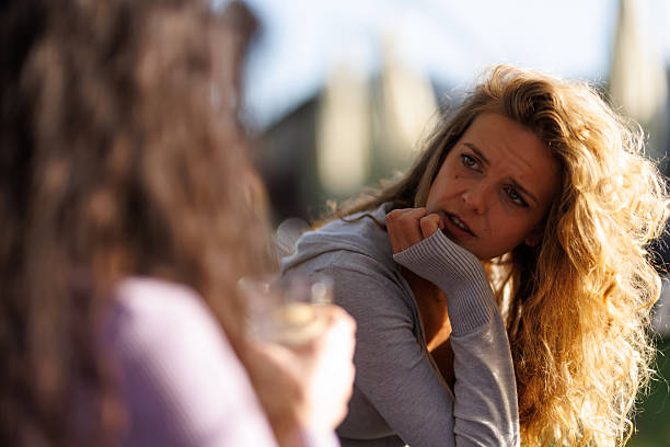 istock Friends engage in deep conversation while enjoying drinks in a sunny outdoor setting during the late afternoon 2239754399