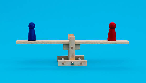 istock Human figures on wooden seesaw 2239755102