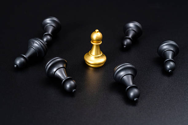 Golden pawn standing and black pawns lying down.