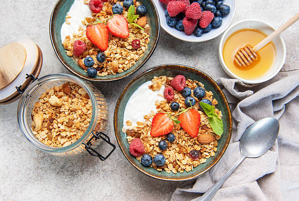 istock Granola bowls with berries, yogurt, nuts, and honey for breakfast 2239756290