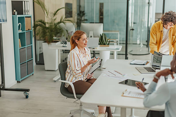 istock Young professionals engage in teamwork and communication during a meeting in a modern office space 2239757684