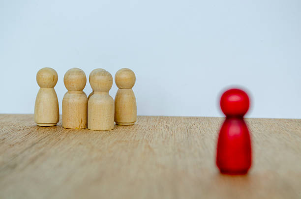 istock Blurred red wooden figure separated from group expressing independence and visionary leadership. 2239759129
