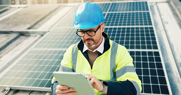 istock Roof, solar panel and tablet with construction worker man in city for installation or inspection. App, building and infrastructure with mature person outdoor photovoltaic or power source maintenance 2239763889