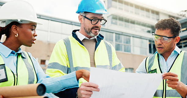 istock Team, blueprint and discussion for urban development or architecture, maintenance or renovation. Construction site, contractor job collaboration and people on rooftop, building floor plan or strategy 2239763934