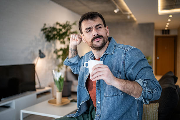 istock Man with itchy ear drinking coffee at home 2239766069