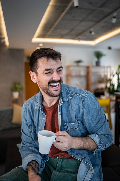 istock Cheerful man laughing and enjoying coffee break 2239766207