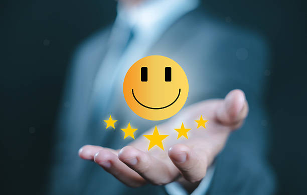 istock Businessman holding a glowing smiley face with five stars, representing customer satisfaction, feedback, service quality, review rating, and positive user experience in business. 2239767811