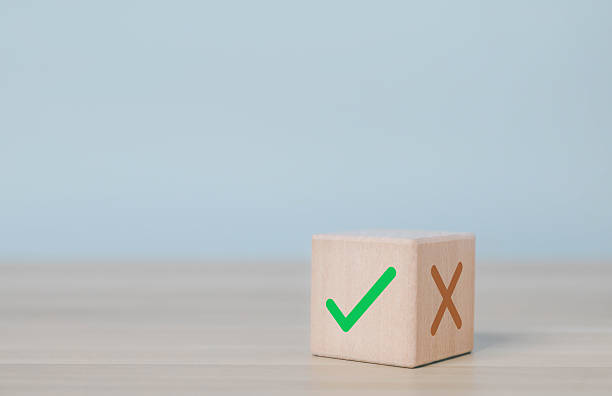 istock Wood cube with check mark and cross sign on table, symbolizing decision making, right and wrong choice, evaluation, approval process, and quality control in business. yes or no concept 2239767860