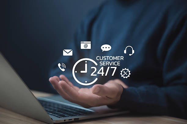 istock Businessman holding 24-hour customer service icon with communication symbols, representing online support, help desk, client care, and business assistance through technology. Contact us concept 2239767862