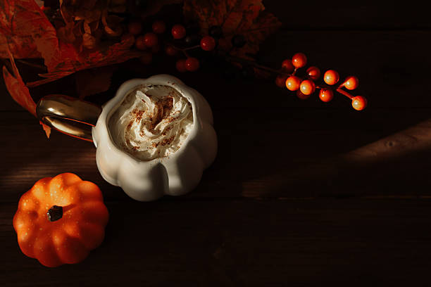 istock Cozy fall scene with a pumpkin flavored drink and autumn decorations on a wooden table 2239768201