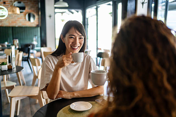 istock Two young women enjoying coffee and conversation at cafe 2239768244