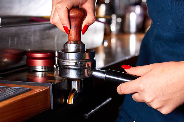 istock Barista using a tamper to press ground coffee into a portafilter 2239768402