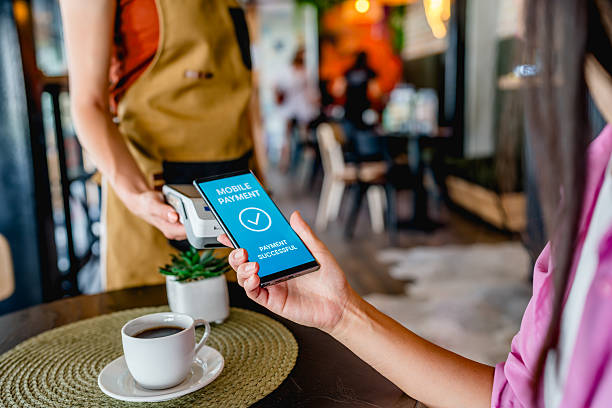 istock Woman making mobile payment at cafe counter 2239768757