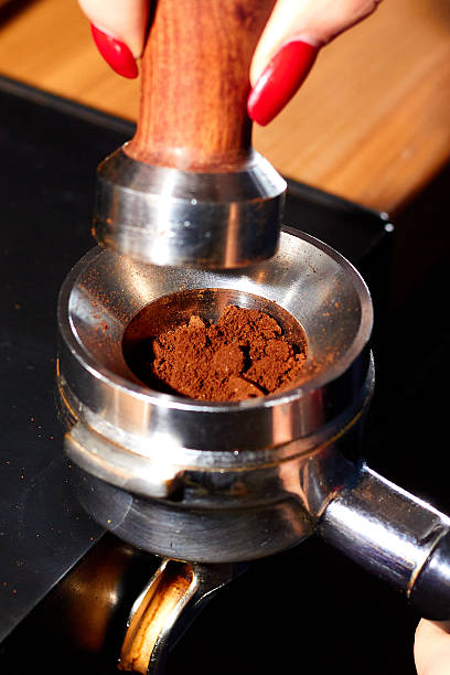 istock Barista using a tamper to press ground coffee into a portafilter 2239768765
