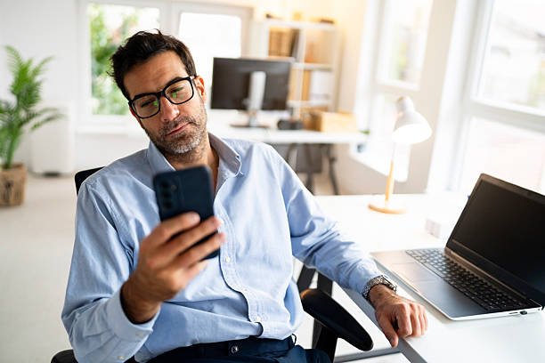 istock Corporate professional checking his mobile device at the desk 2239769182