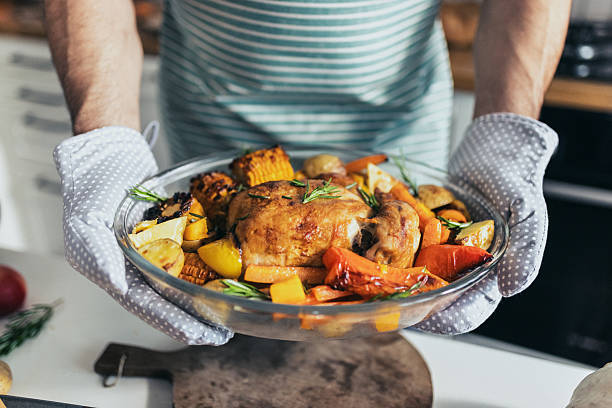 A delicious, golden-brown roasted chicken garnished with colorful vegetables while being served directly. The dish exudes warmth, freshness, and homemade comfort for a perfect family meal.