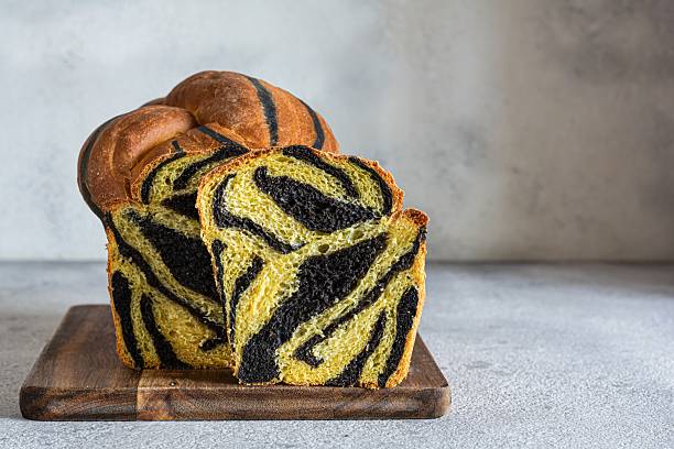istock Pumpkin marbled (tiger print) bread with cuttlefish ink, braided on a light background. Useful home baking. Texture laid out from slices of bread. 2239772032