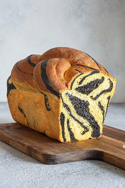istock Pumpkin marbled (tiger print) bread with cuttlefish ink, braided on a light background. Useful home baking. Texture laid out from slices of bread. 2239772033