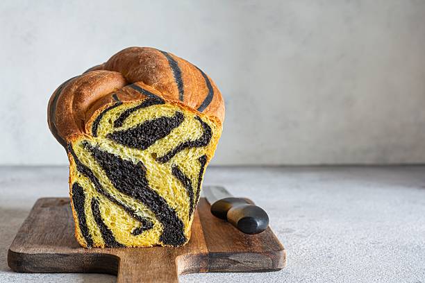 istock Pumpkin marbled (tiger print) bread with cuttlefish ink, braided on a light background. Useful home baking. Texture laid out from slices of bread. 2239772034