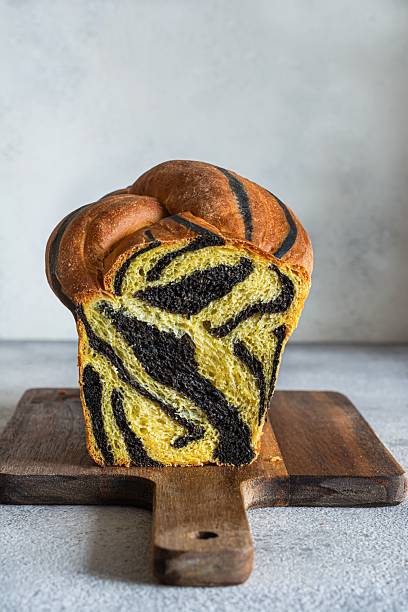 istock Pumpkin marbled (tiger print) bread with cuttlefish ink, braided on a light background. Useful home baking. Texture laid out from slices of bread. 2239772035