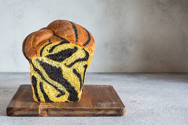 istock Pumpkin marbled (tiger print) bread with cuttlefish ink, braided on a light background. Useful home baking. Texture laid out from slices of bread. 2239772065