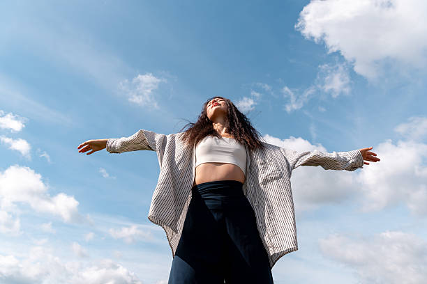 istock Gen Z woman relaxing under the blue sky, low angle view 2239772115