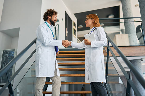 istock Doctors shaking hands on staircase in clinic 2239785724