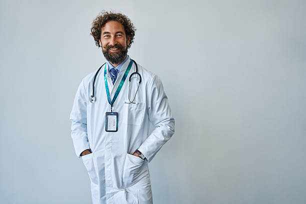 istock Confident male doctor smiling standing with lab coat 2239785841