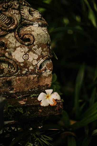 istock Weathered stone sculpture with flower 2239787362