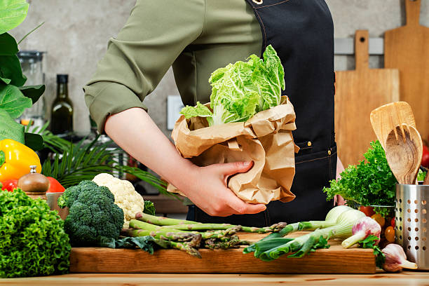 istock Private chef works in modern kitchen, arranging fresh vegetables and herbs on cutting board for healthy meal preparations 2239789294