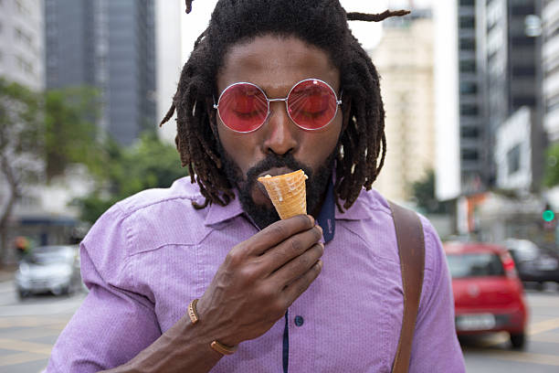 African american man eating in the streets ice cream cone.