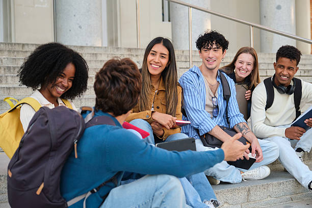 istock Diverse university students talking and smiling on campus stairs 2239797103