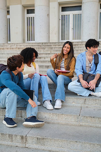 istock Diverse students talking and laughing on university campus stairs 2239797186