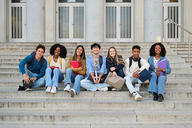 istock Diverse students sitting on campus stairs holding books 2239797216